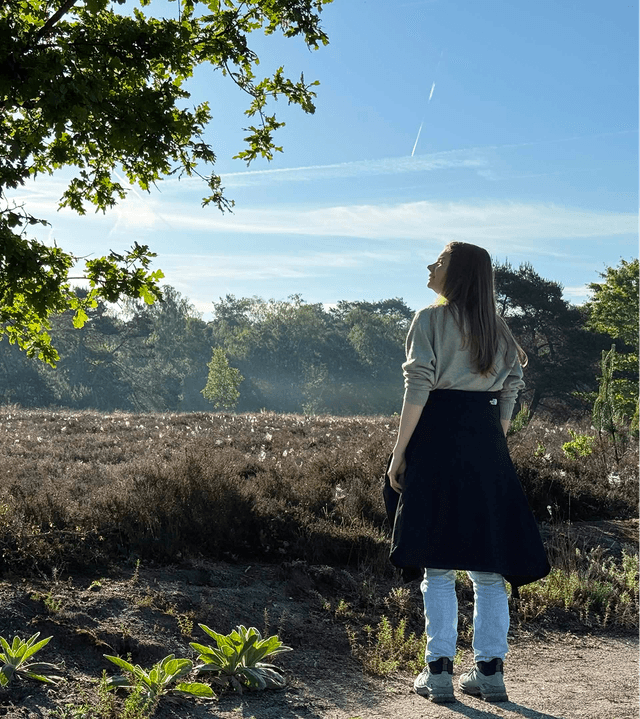 Photo of Elyse in a field in nature on a sunny day